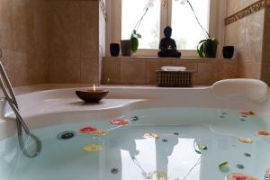 a bathroom with a bath tub with a candle in it at Hotel Zamek Berchtold in Strančice