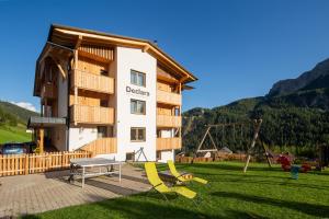 a building with a playground in the grass in front of it at Declara B&B and apartaments in Colfosco