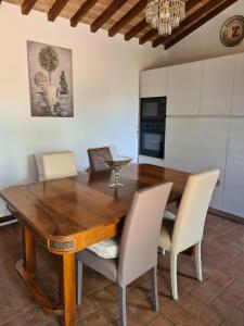 een eetkamer met een houten tafel en stoelen bij Villa Le Ginestre in Cortona