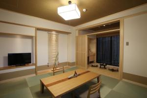a living room with a table and a television at Wakasa Annex in Nara