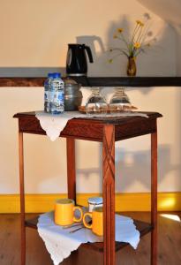 a wooden table with cups and plates on it at Le Clos des Pommes in Bioncourt