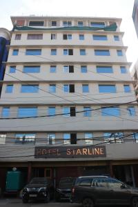 a hotel building with cars parked in front of it at Hotel Starline in Guwahati