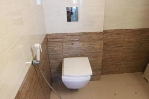 a bathroom with a toilet and a phone on a wall at Hotel Starline in Guwahati