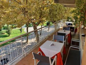 rzędu stołów i krzeseł na balkonie z drzewami w obiekcie Hotel Cormorano w mieście Pedaso
