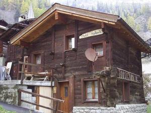 uma cabana de madeira com um sinal ao lado em wooden chalet in Betten near the Aletsch Arena em Betten