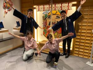 a group of people posing for a picture in a room at Namba Ebisu Hotel in Osaka