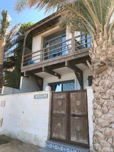 a house with a wooden door and a palm tree at Ganesha.Beach apartment in Dahab