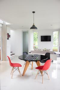 une salle à manger avec une table et deux chaises rouges dans l'établissement The Dago View Bandung, à Bandung
