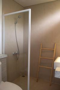 une douche dans une salle de bain avec une porte vitrée dans l'établissement The Dago View Bandung, à Bandung