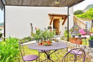 a patio with a table and chairs in a yard at La Maison De Noelie - stunning house for rent in Le Bar-sur-Loup