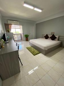 a bedroom with a bed and a desk in it at Burapha Bangsaen Garden Apartment in Bangsaen