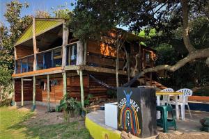 a log cabin with a table and chairs in front of it at Blue Space Beach Shack in Hibberdene
