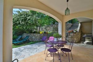 a patio with a table and chairs and a stone wall at La Pascaline Registered Accomodation 4 , Gites in France , Recommended By l in Le Bar-sur-Loup