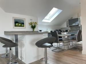 a kitchen with black chairs and a counter with a table at Lough Key Luxury Riverfront Apartment in Cootehall