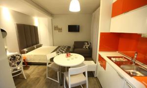 a small room with a table and a bed and a kitchen at Mary's Luxury in Chrysi Ammoudia