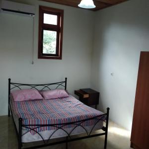 a bedroom with a bed with two pillows and a window at Hotel Poseidon in Shekvetili
