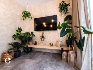 a living room with plants and a tv on a wall at JUMBO APARTMENTS in Rajecké Teplice