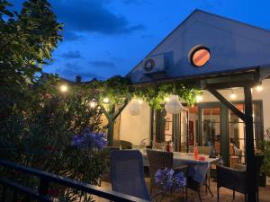 a patio with a table and chairs and lights at Mandula House in Paloznak