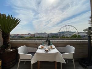 a table and chairs on a balcony with a ferris wheel at Vista Suites 1-2 in Budapest