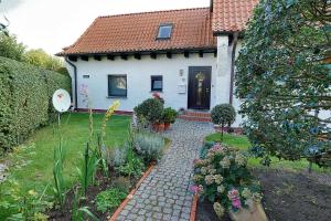 uma casa com um passadiço de tijolos em frente a um quintal em Barth, Dieter em Zingst