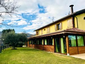 ein Haus mit einem Rasenplatz davor in der Unterkunft Azienda agricola biologica Le Lucciole in Bertinoro