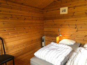 um quarto com uma cama numa parede de madeira em 2 persoons stuga em Hammarstrand