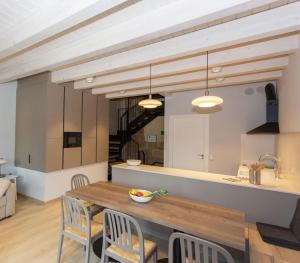 eine Küche und ein Esszimmer mit einem Holztisch und Stühlen in der Unterkunft La Casa de los Mil Años in Estella