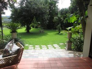 a patio with a park with a bench in the grass at Almar View Guest House in Nelspruit