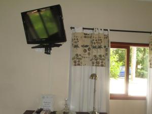 a television hanging on a wall next to a window at Almar View Guest House in Nelspruit