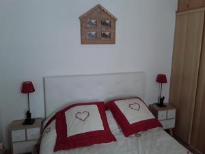 a bedroom with a bed with two red and white pillows at quereuilh in Le Mont-Dore