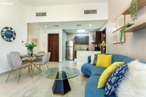 a living room with a blue couch and a table at bnbmehomes - Elegant Apt In Al Barsha South - 613 in Dubai
