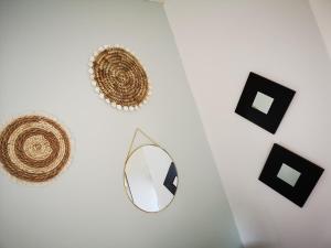 una pared blanca con espejo y objetos en blanco y negro en Emel b&b, en Laville-aux-Bois