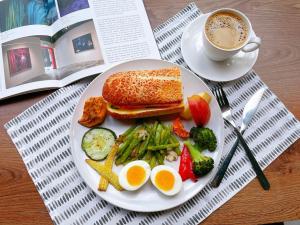 un plato de comida con huevos y verduras y una taza de café en Onsense Villa, en Jiaoxi