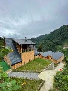 a wooden house with a roof on a hill at OTANİ DAĞ EVLERİ in Çamlıhemşin