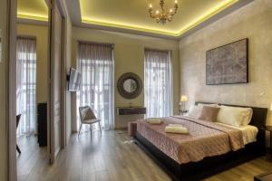 Un dormitorio con una cama grande y una lámpara de araña. en Plaka Filotheis House B, en Atenas