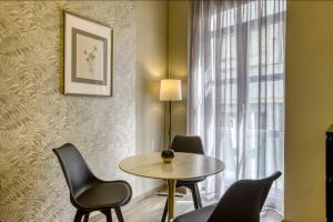 Una habitación con una mesa y sillas y una ventana. en Plaka Filotheis House B, en Atenas