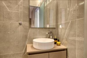 Un baño con un lavabo blanco y un espejo. en Plaka Filotheis House B, en Atenas
