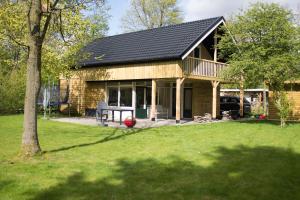 een huis met een gambrel dak en een tuin bij Vakantiepark De Kremmer in Gasselte