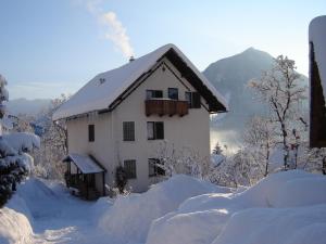 a house is covered in snow in the mountains at Apartment Makuc in Bovec