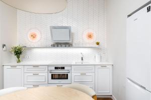 a kitchen with a table and a tv on a wall at V33 cozy apartment in Druskininkai