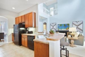 a kitchen with a sink and a refrigerator at Velleux Escape at Reunion Resort by Shine Villas in Kissimmee