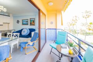 a balcony with chairs and a table and a kitchen at Cubo's Apartamento Perla del Sol Rosa in Torremolinos