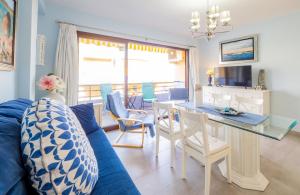 トレモリノスにあるCubo's Apartamento Perla del Sol Rosaのリビングルーム(青いソファ、テーブル付)