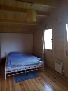 sypialnia z łóżkiem w drewnianym pokoju w obiekcie Dom Pod Sosnami w mieście Lidzbark