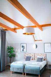 Habitación con 2 camas y techo con vigas. en Restauracja Balton, en Grajewo