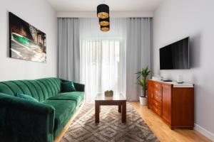 華沙的住宿－Millennium Express Green，客厅配有绿色沙发和电视