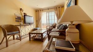 a living room with a table with a lamp and a tv at Apartments Bambu in San Agustin