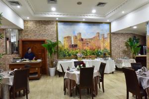 a dining room with tables and a painting on the wall at Hôtel Fès Inn & SPA in Fez