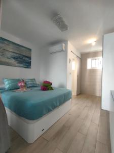 a bedroom with a large bed with blue sheets at BLU in Puerto del Carmen