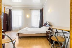 a small bedroom with a bed and a table and chairs at Best Apartment in the city centre in Odesa